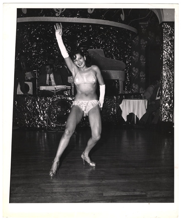 Showgirl dancing in front of band