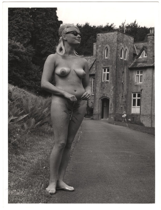 Woman standing with fern leaf