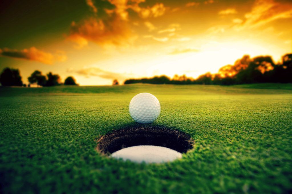sinking a putt at sunset