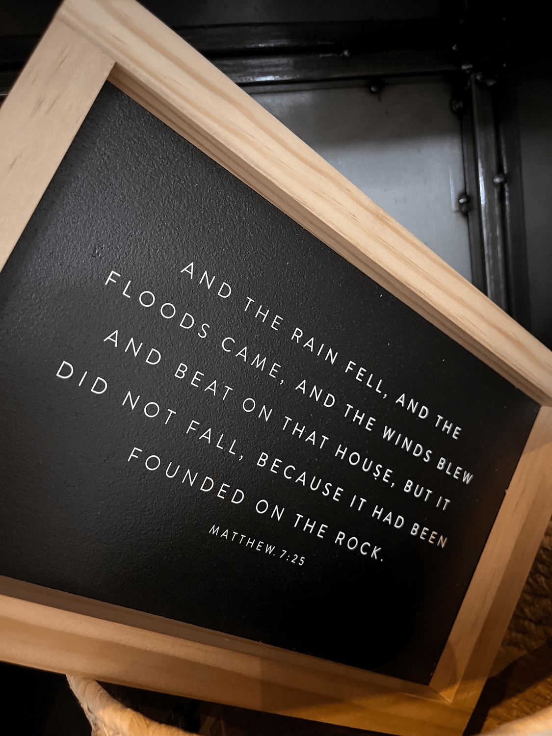 And the Rain Fell Black Sign With Light Wood