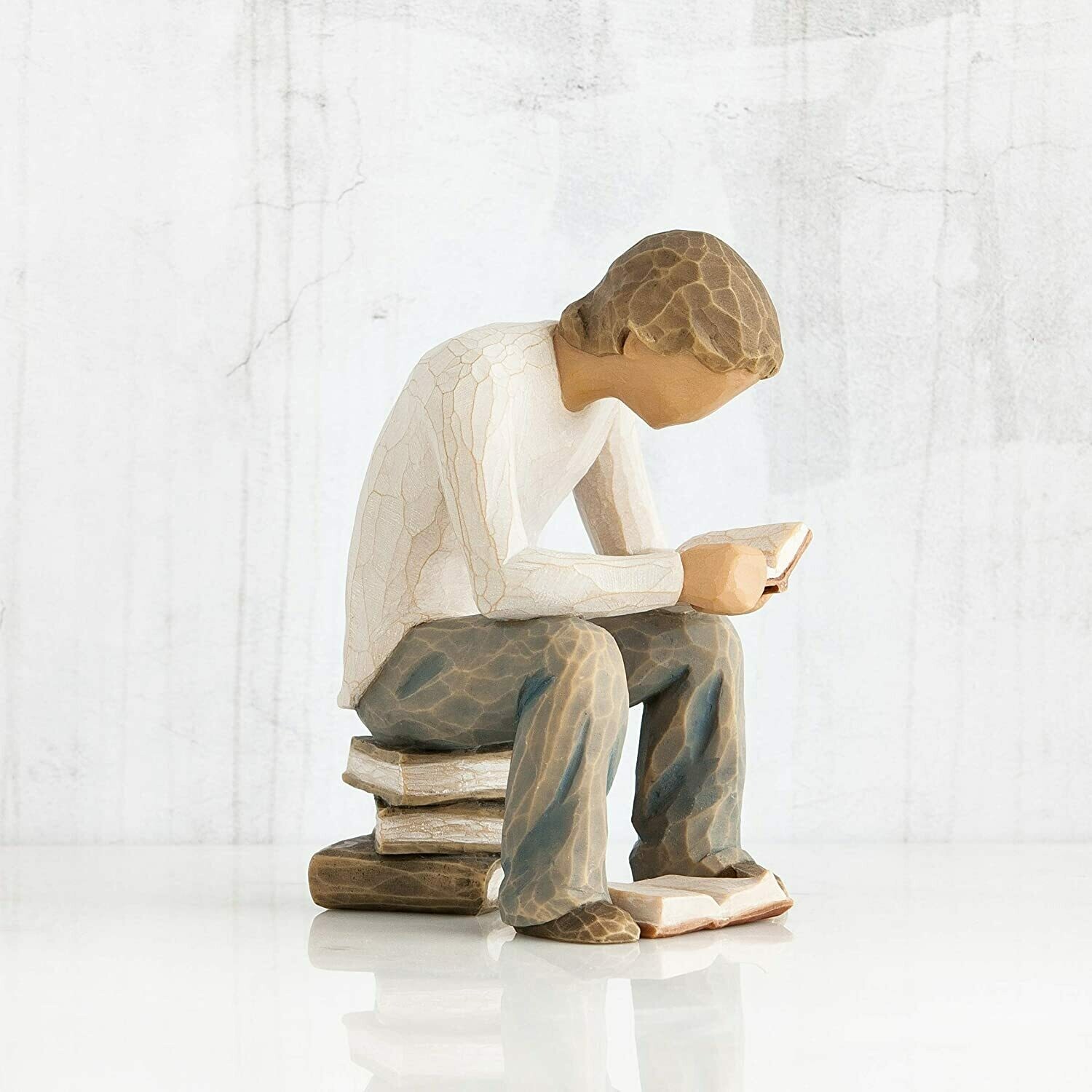 Willow Tree Quest Graduation Boy sitting on pile of books with