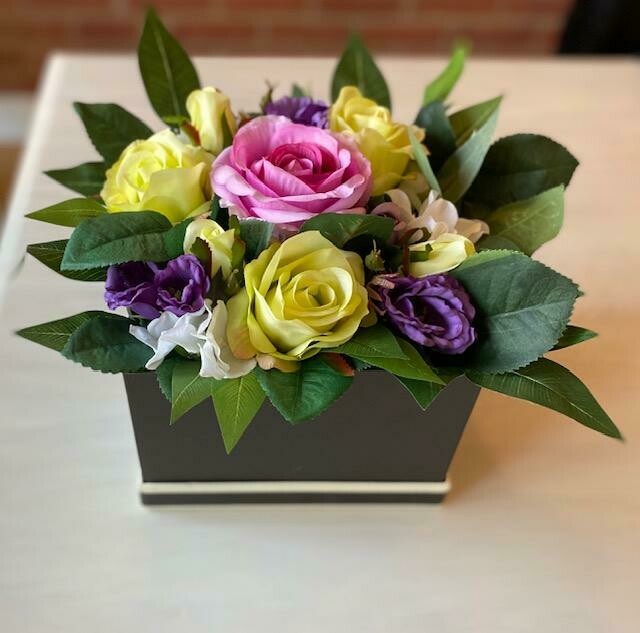 large colourful flowers in a black hat box