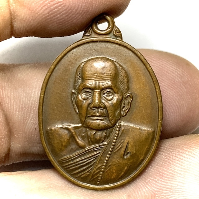 Rian Luang Phu Hmun Laekh 1 first edition coin amulet in the hand for size comparison