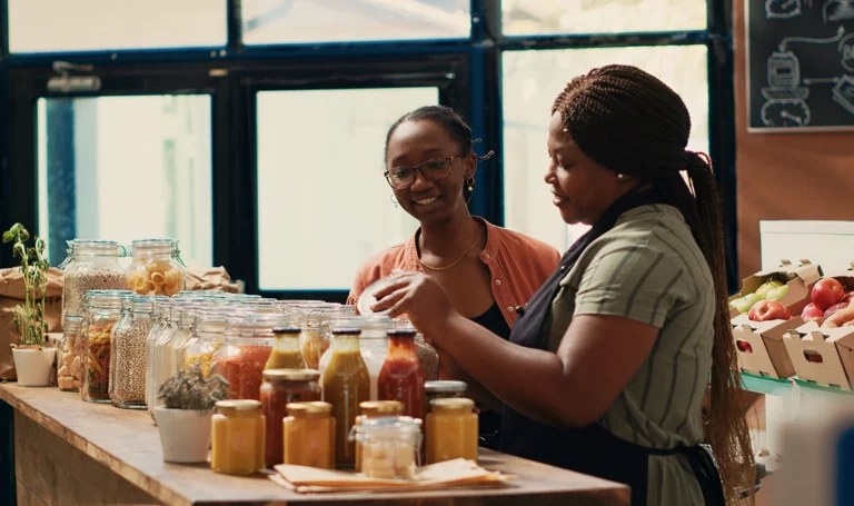 Vendor giving fresh homemade sauces to a customer.