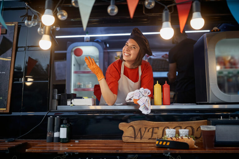 Female food truck worker posing at counter.