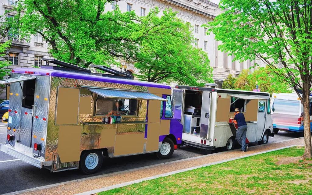 Two food trucks parked along a brick sidewalk on a street in Washington, D.C.