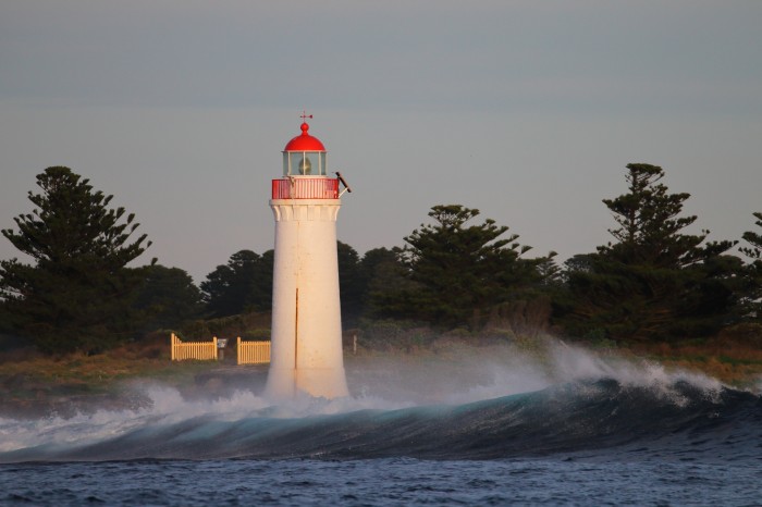Lighthouse and wave in Port Fairy, Victoria; photo by Ed Dunens