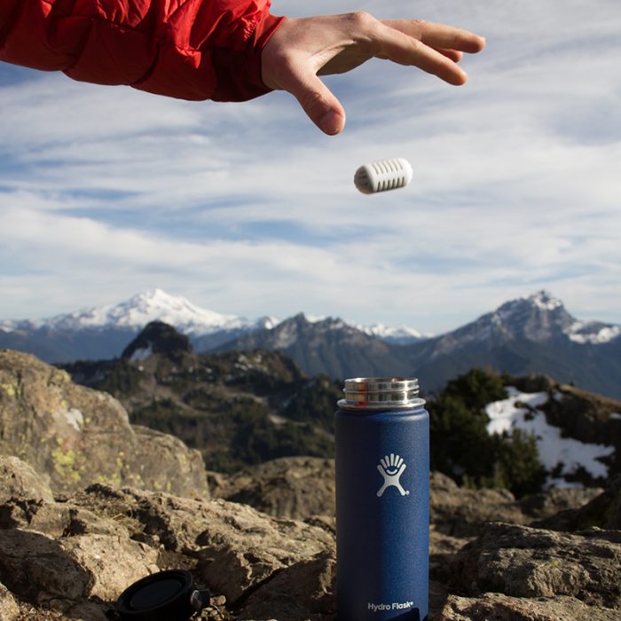 hand dropping a gopure filtration pod into hydro flask