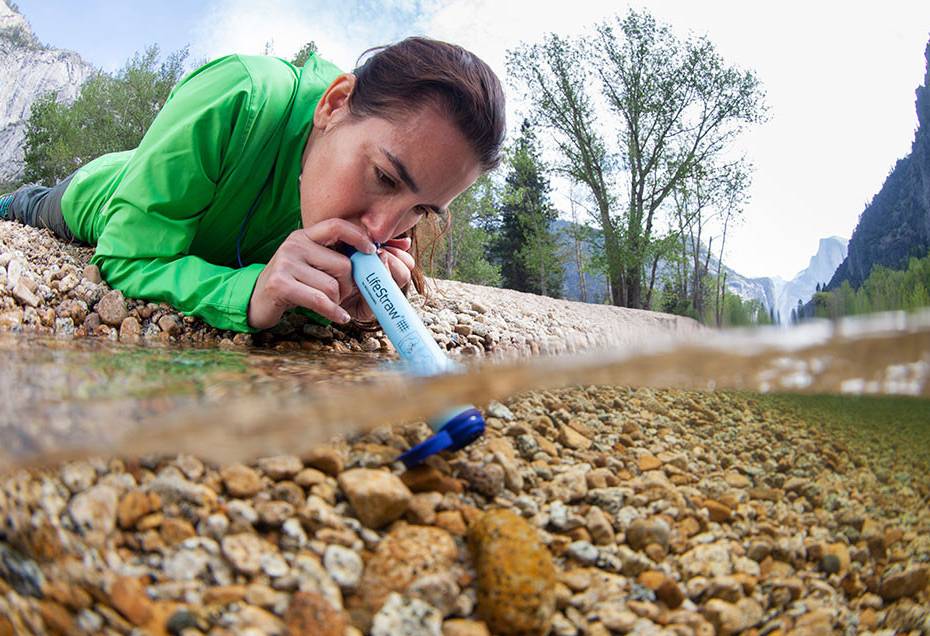 The Bestselling Gear at Amazon This Week Woman Using LifeStraw Personal Water Filter in Stream