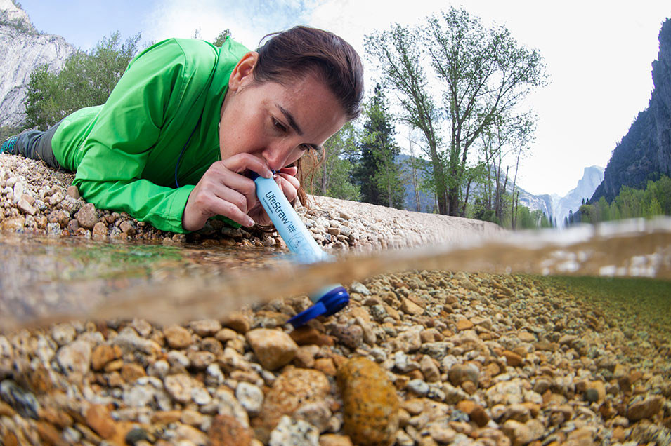 Woman Using LifeStraw Personal Water Filter in Stream