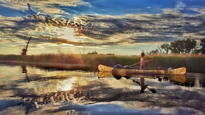 Michael Anderson cleans a river in Minnesota by canoe; photo credit: Paul Twedt