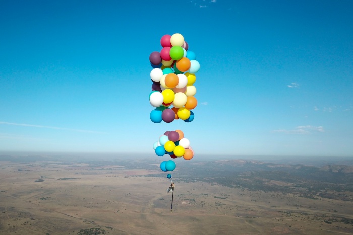 helium balloons lift chair and person