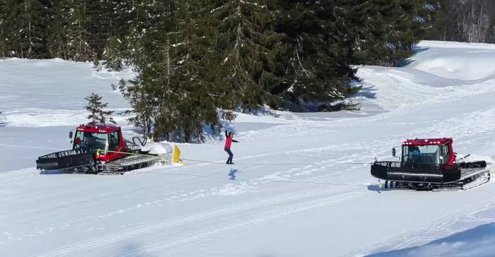 slackline between two snowcats