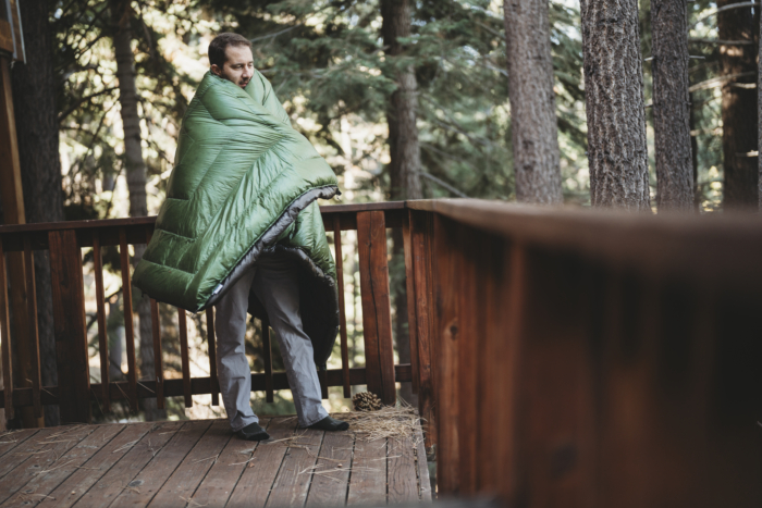 a man getting wrapped up in the enlightened equipment revelation quilt