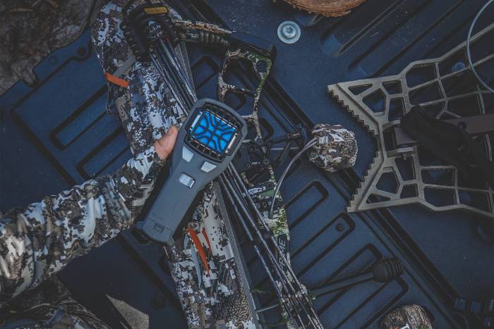 thermacell mr450 held in a hand over a truck bed full of hunting equipment