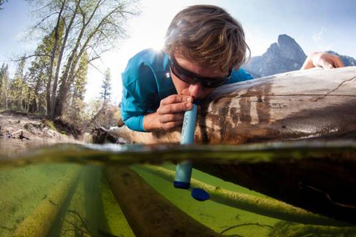 Man drinking from water with LifeStraw