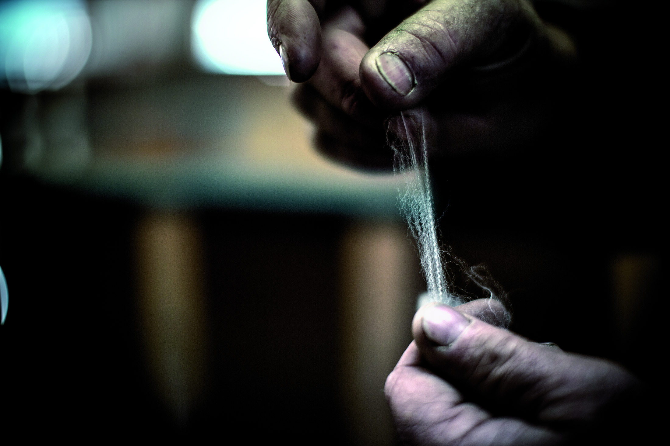 Person pulling apart Icebreaker merino wool fiber Person pulling apart Icebreaker merino wool fiber