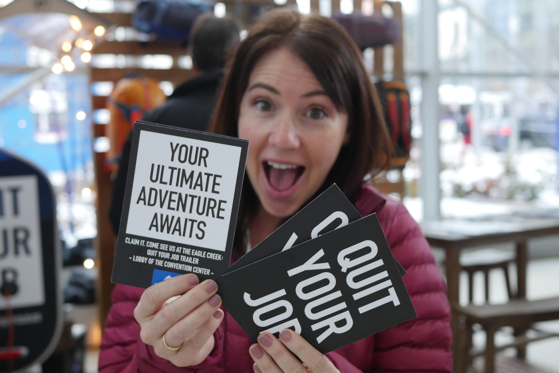 Excited woman holding up Eagle Creek Quit Your Job Tour info cards Excited woman holding up Eagle Creek Quit Your Job Tour info cards