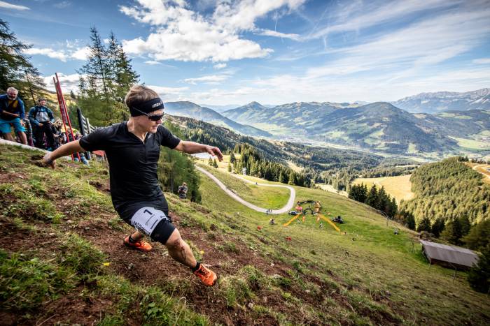Person running downhill muddy course in Kitzbühel