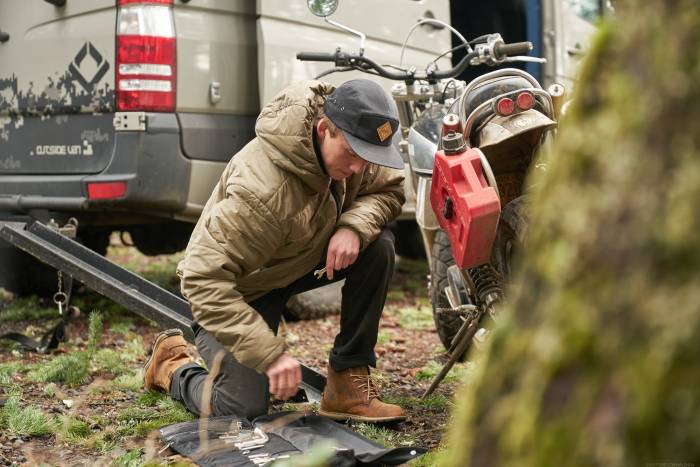 man using tools in velomacchi speedway tool roll alongside motorbike