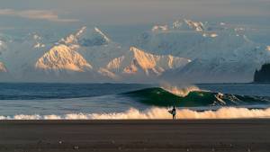 surfing on shore looking out at water in Alaska