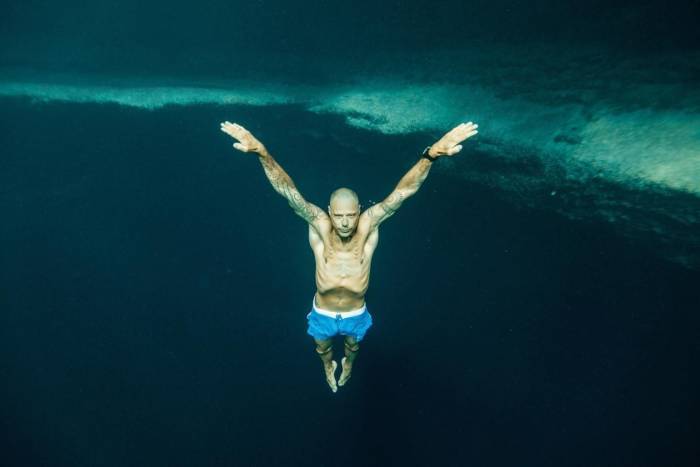 Stig Pryds Diving deep in ocean with arms outstretched