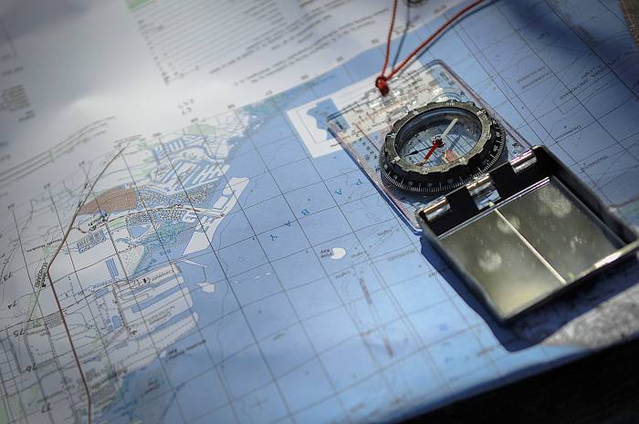 Compass open over close up of nautical map