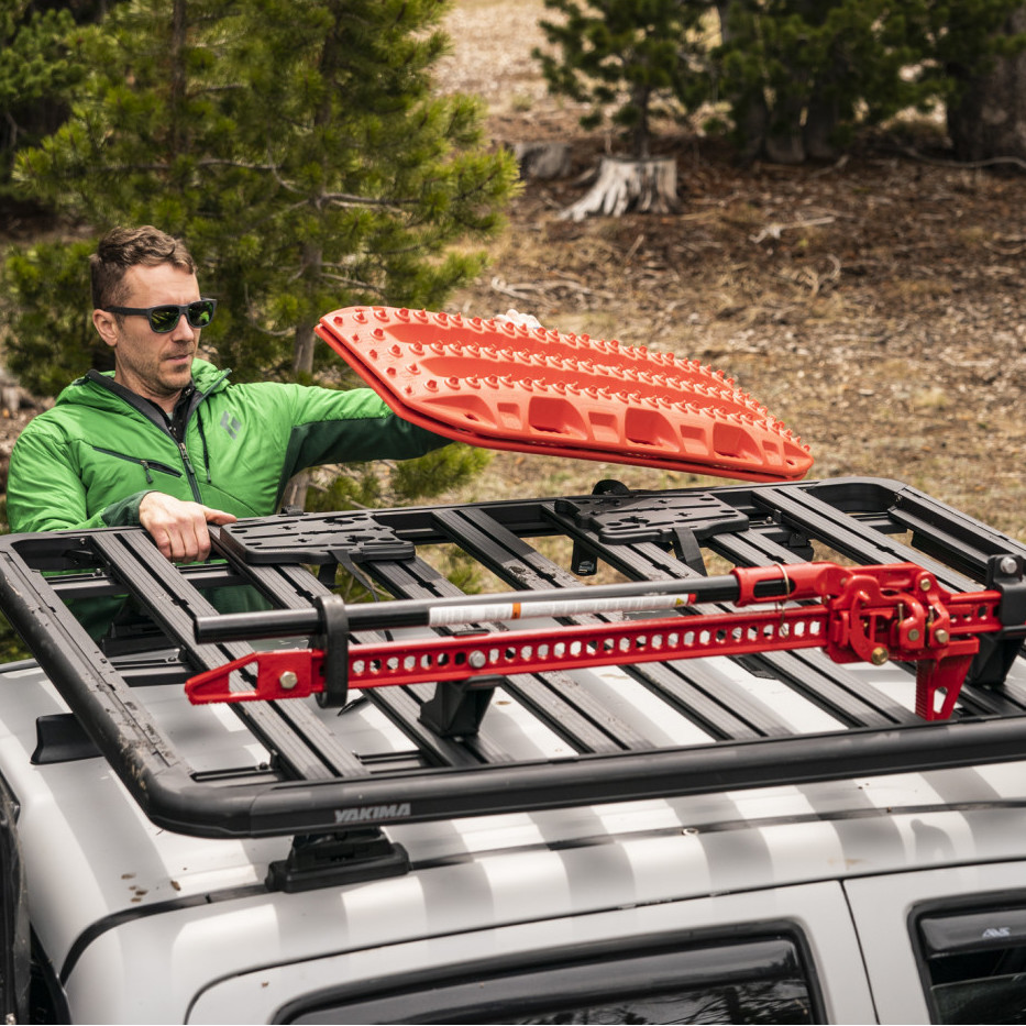 Man loading skis and gear onto Yakima LockNLoad Rooftop rack