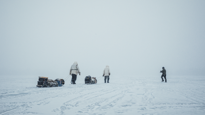 two Native American people trekking through snow in snow camping film