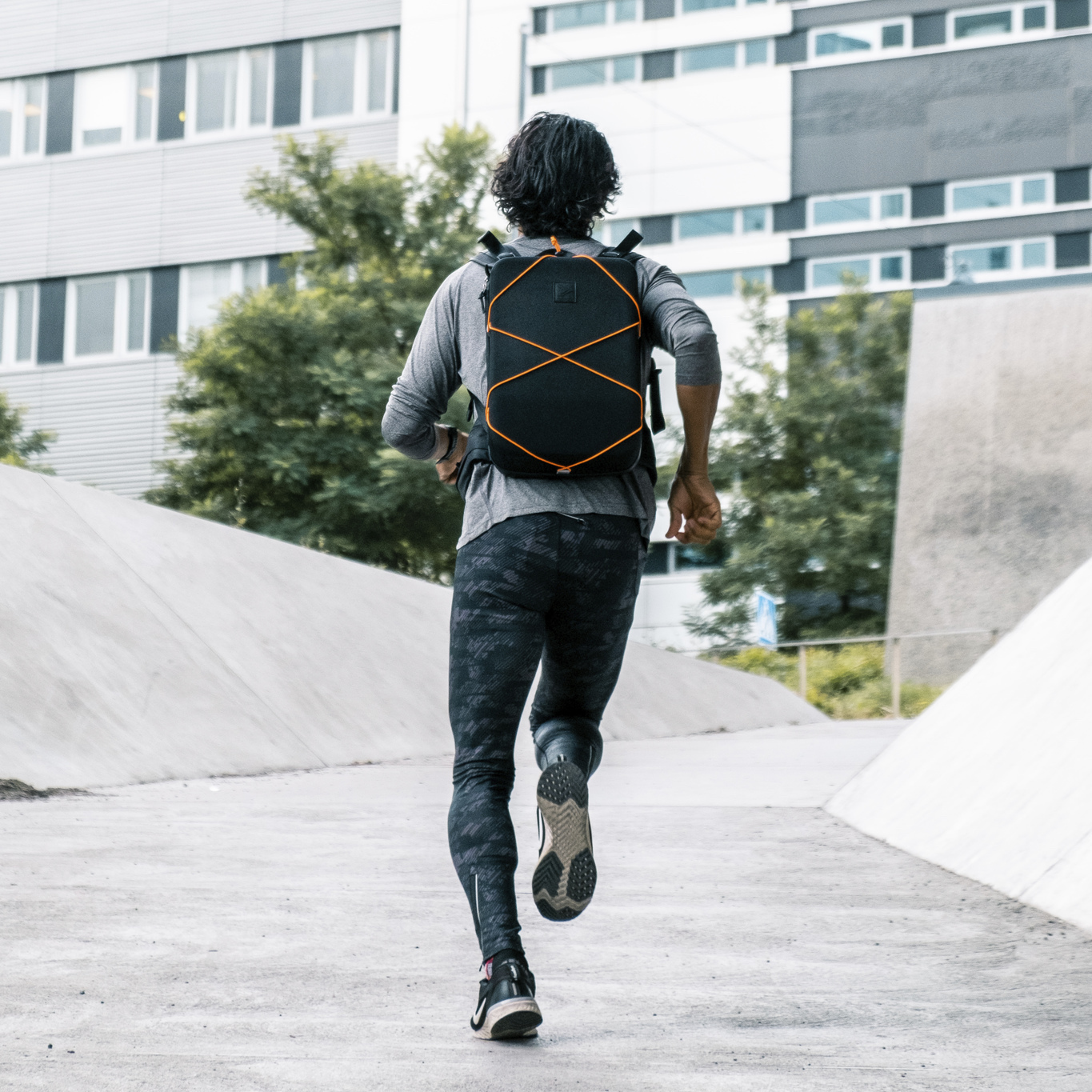 man wearing IAMRUNBOX running backpack running away from camera