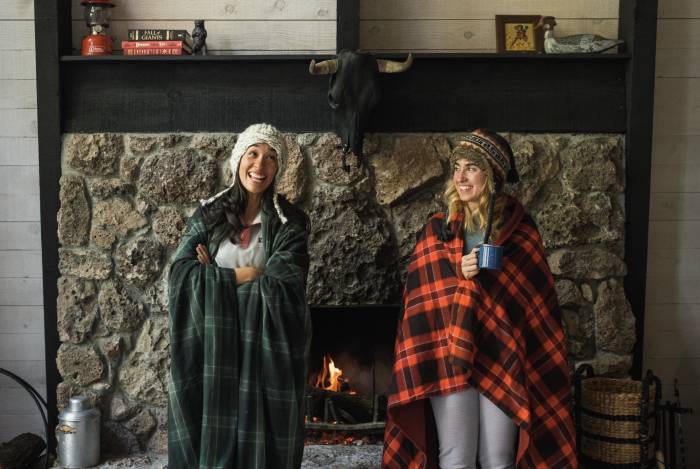 Ladies in Wrapped in Blankets By Fireplace REI
