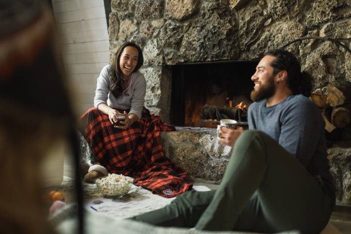 Two People Relaxing by Fire with Blanket