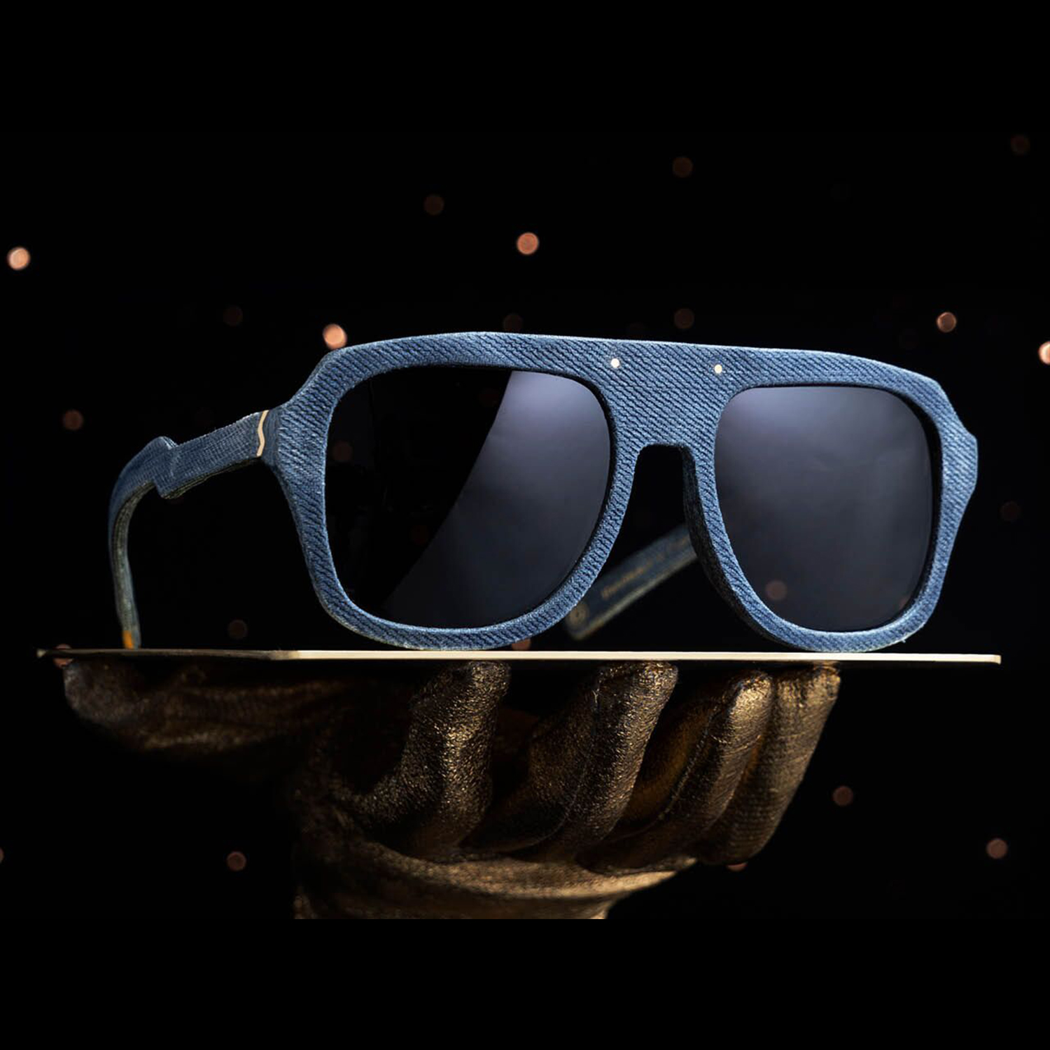 Mosevic Shades of Denim sunglasses resting on sculptured hand