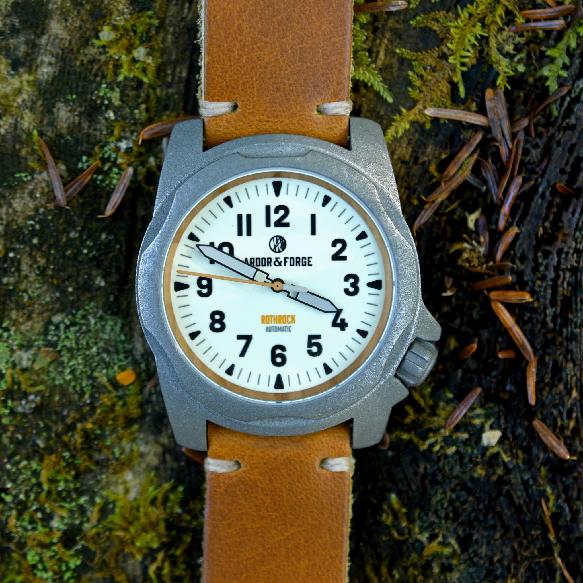 Arbor & Forge Rothrock watch with tan strap against mossy background