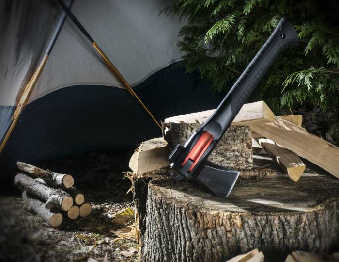 Adventure Mate Hatchet Tool leaning against cut logs and stump next to camp tent