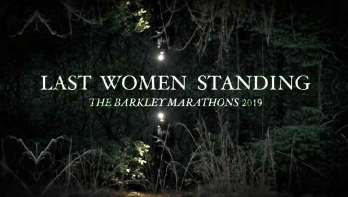 a woman running through a forest at night with shining headlamp during the 2019 Barkley marathons