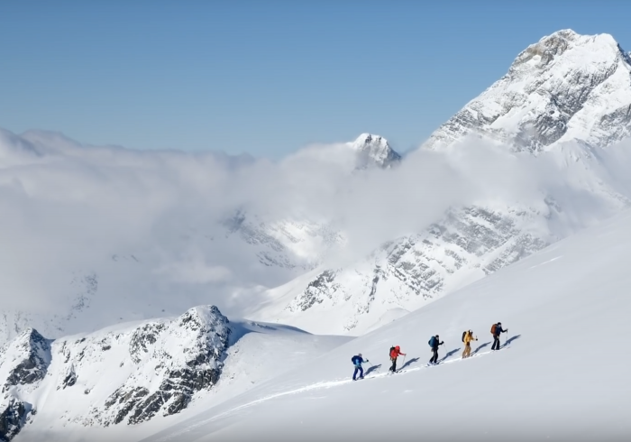 Katie Burrell and four other skiers skinning uphill