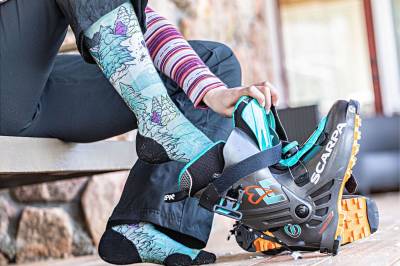 skier putting on Smartwool socks and ski boots