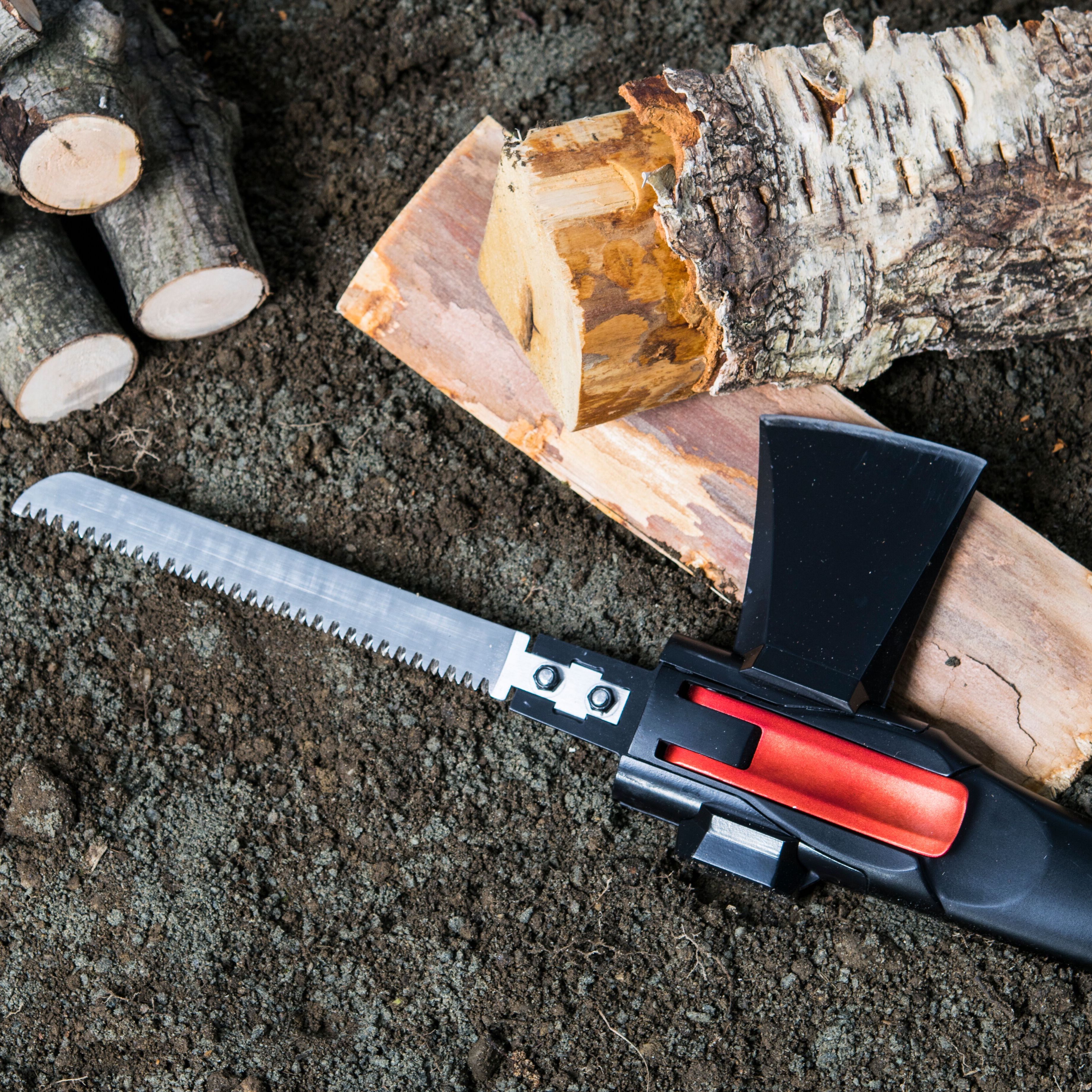 Adventure Mate hatchet and saw tool next to cut log