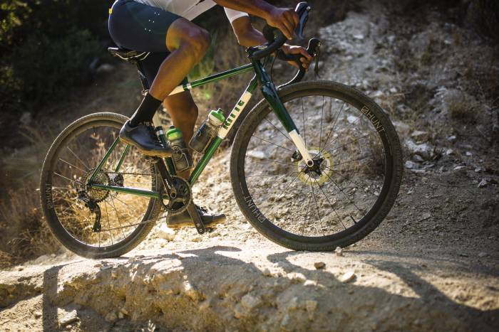 tan person riding a Ritte Satyr Gravel Bike with green frame