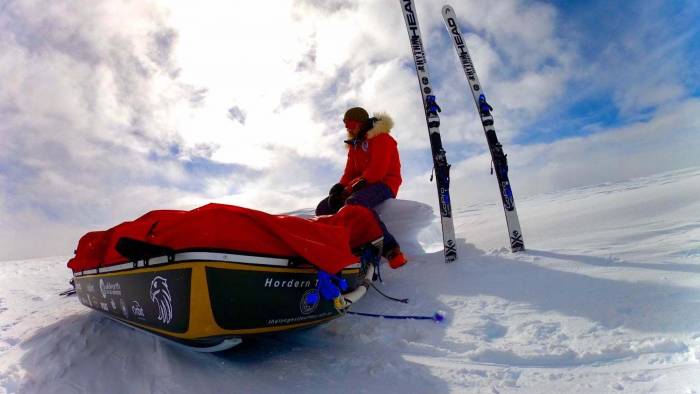 geoff wilson with his sled and skis resting on a bank of snow