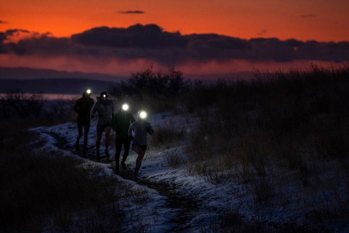 Trail Runners Wearing Black Diamond Headlamps with orange sunset in background