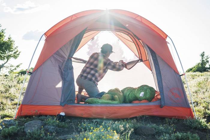 man zipping open door in 4-person Big Agnes tent