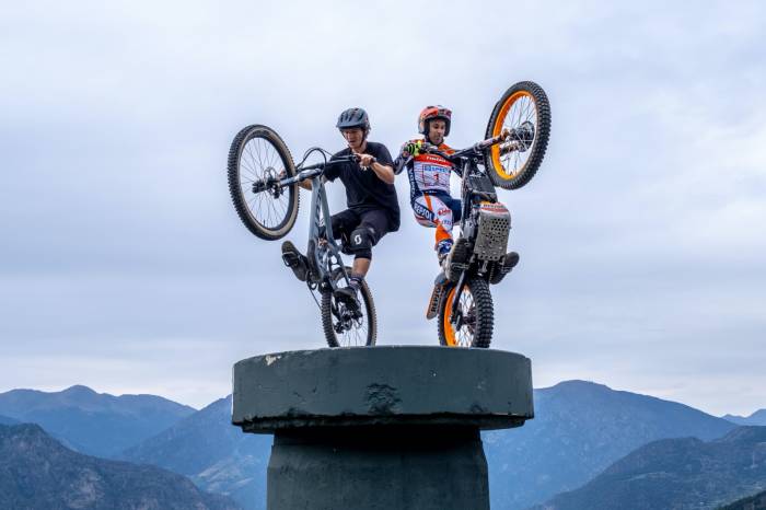 two BMX riders on cement pillar ready to drop into a stunt