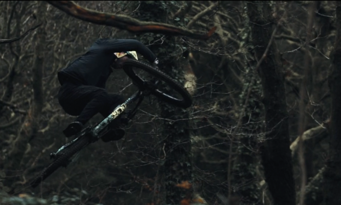 Nikki Whiles mountain biker doing a jump on trail