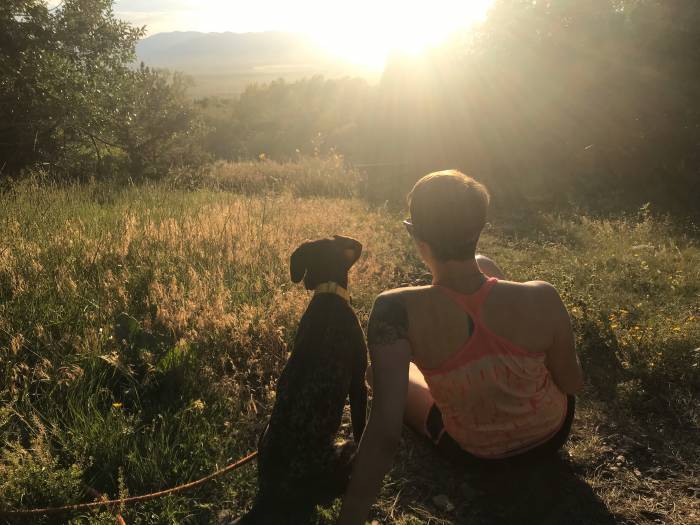 Dog and woman at sunrise