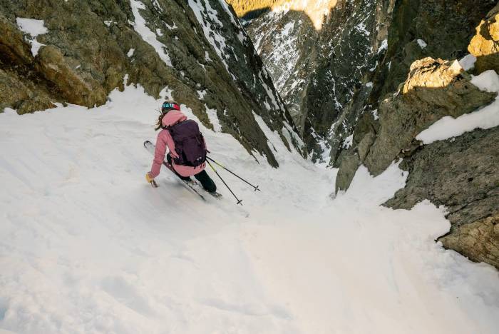 skier dropping into narrow gulley in Sawtooths.