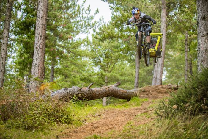 rider Danny Macaskill catching some air with kid in bike trailer behind him