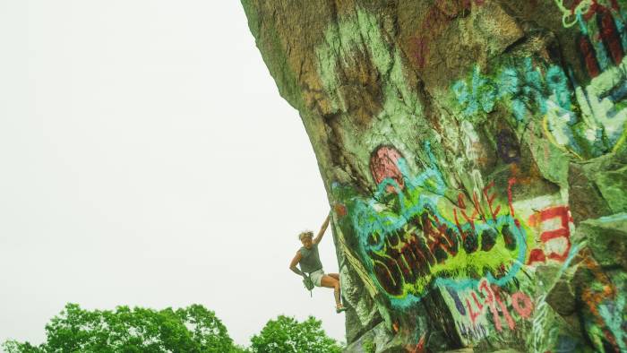 Piseth Sam climbing on graffitied wall