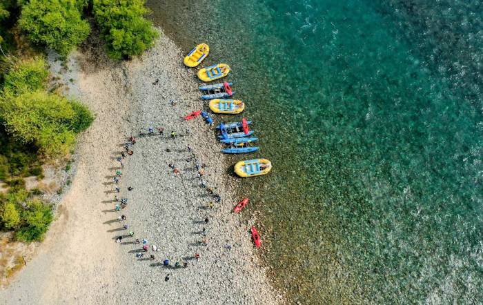 birds eye view of First Descents paddlers and rafts on rocky shore
